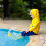 kid in a raid coat by the pool after a storm